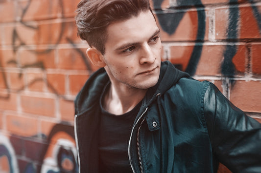 man standing against brown wall