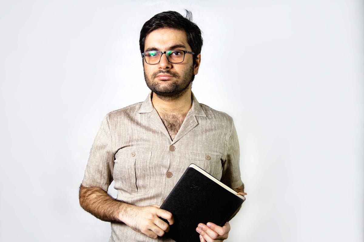 man in brown button up shirt holding black tablet computer