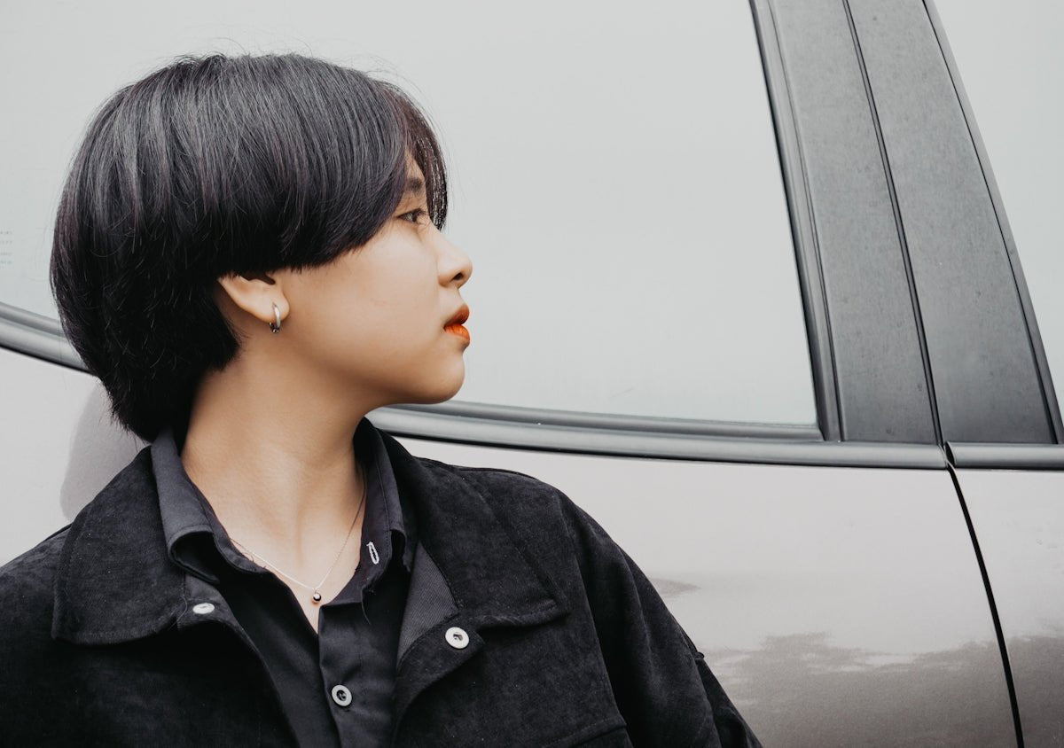 woman in black jacket looking at the window