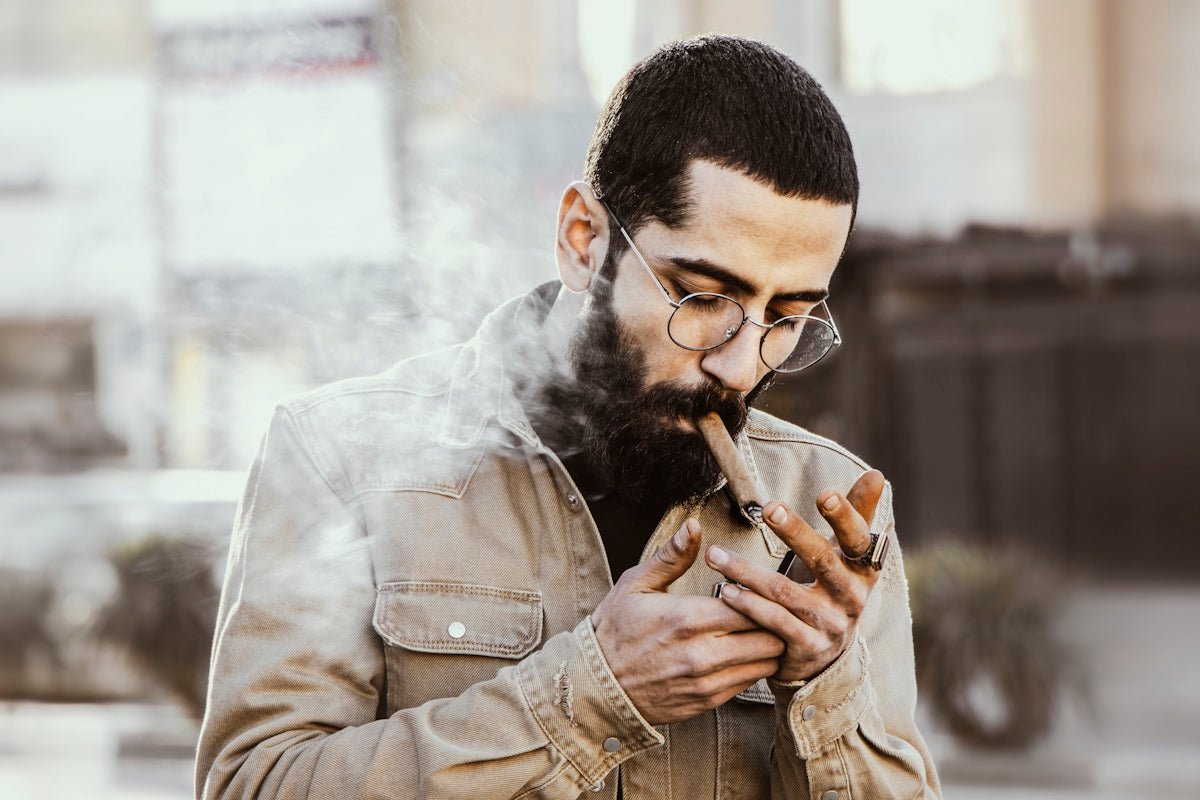 man in brown jacket smoking cigarette