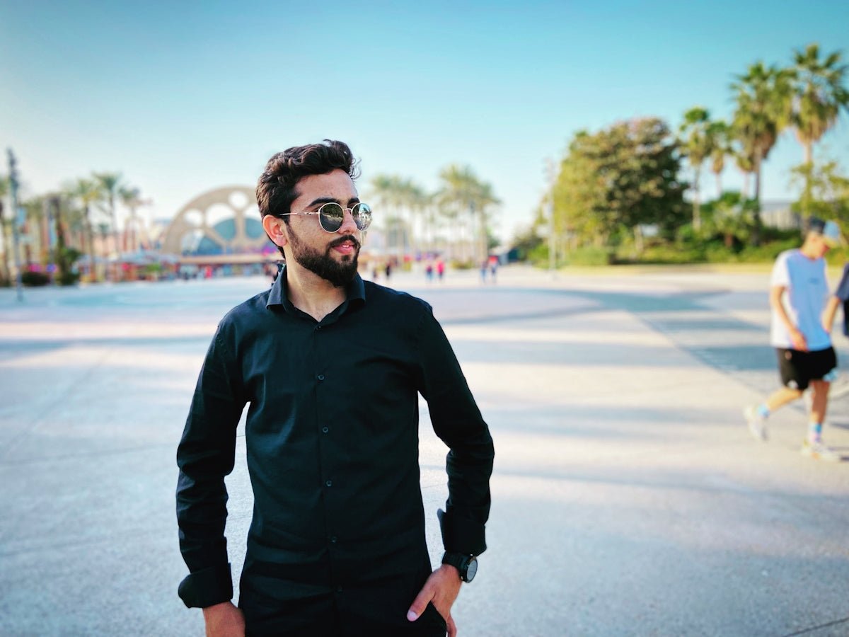 a man standing in a parking lot with his hands in his pockets