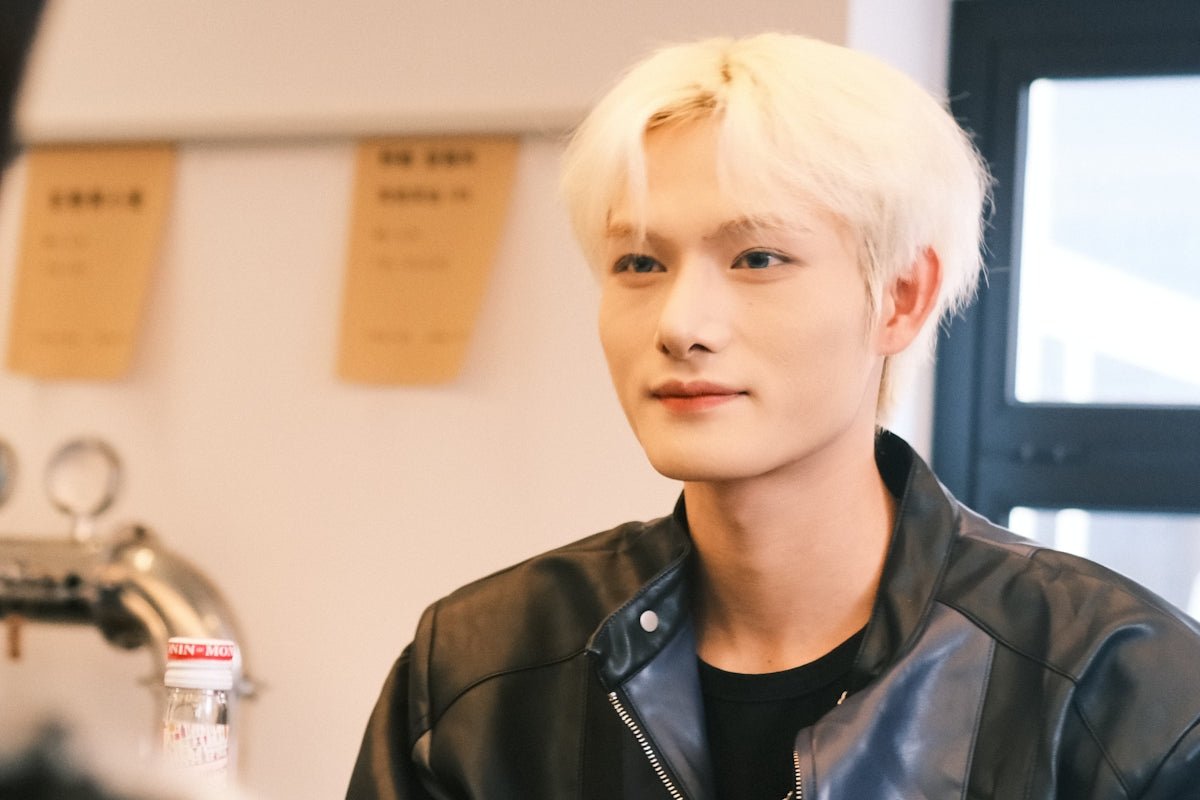 a man with white hair wearing a black jacket