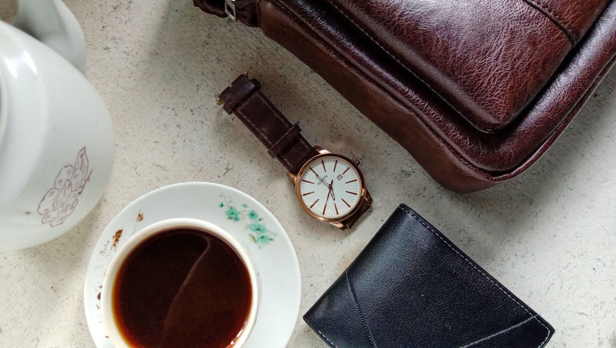 Coffee and leather accessories lay on a surface.
