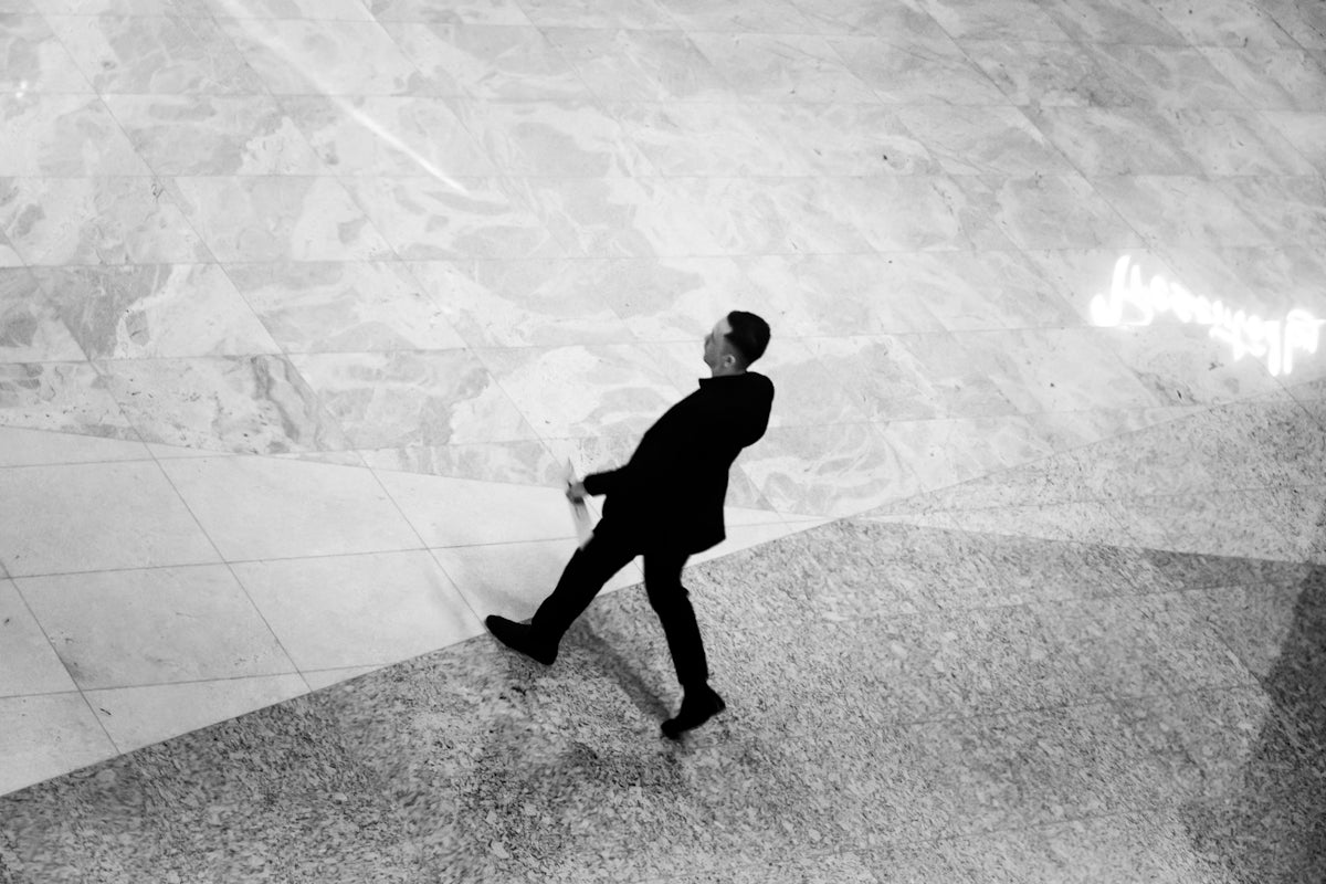 Man in suit walking across marble floor