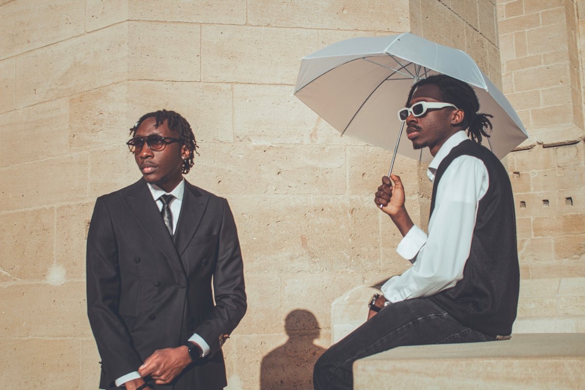 Two men in suits with an umbrella
