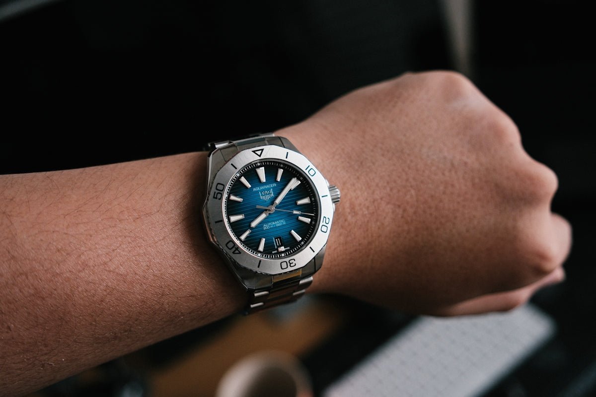 A person wearing a stainless steel watch