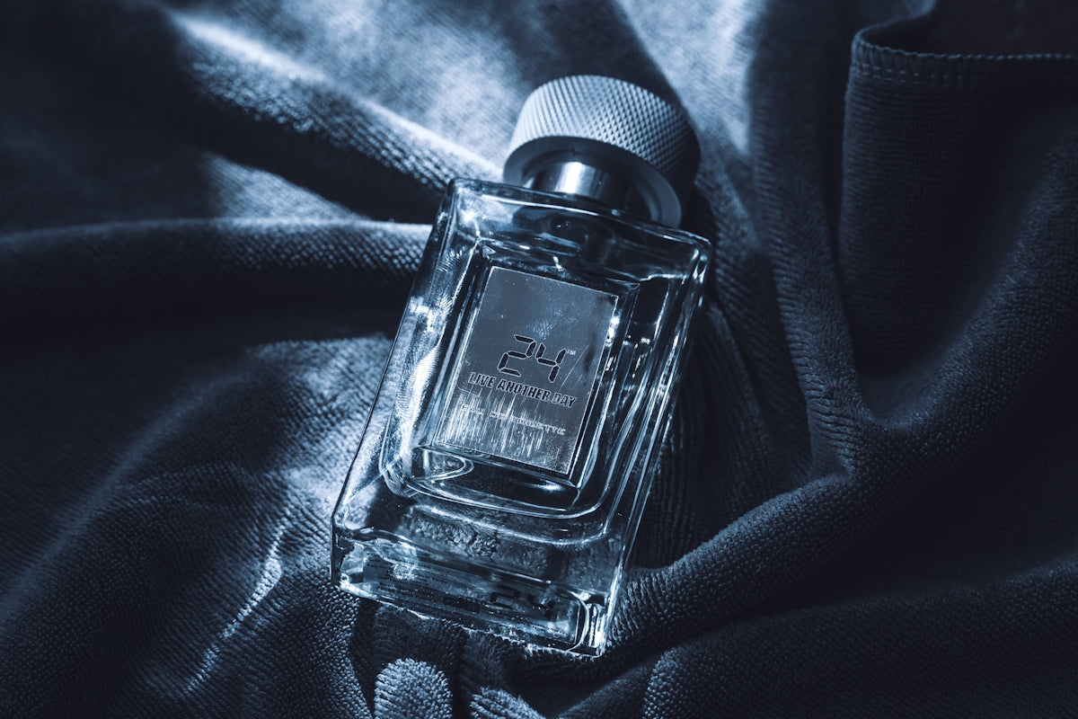 A clear glass perfume bottle with a silver label