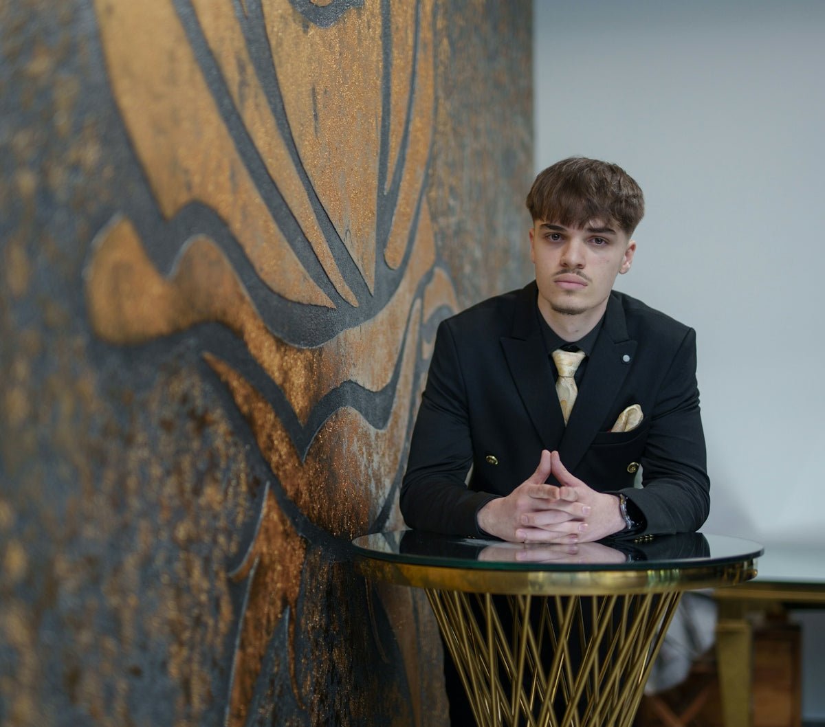 Young man in a suit leaning on a table