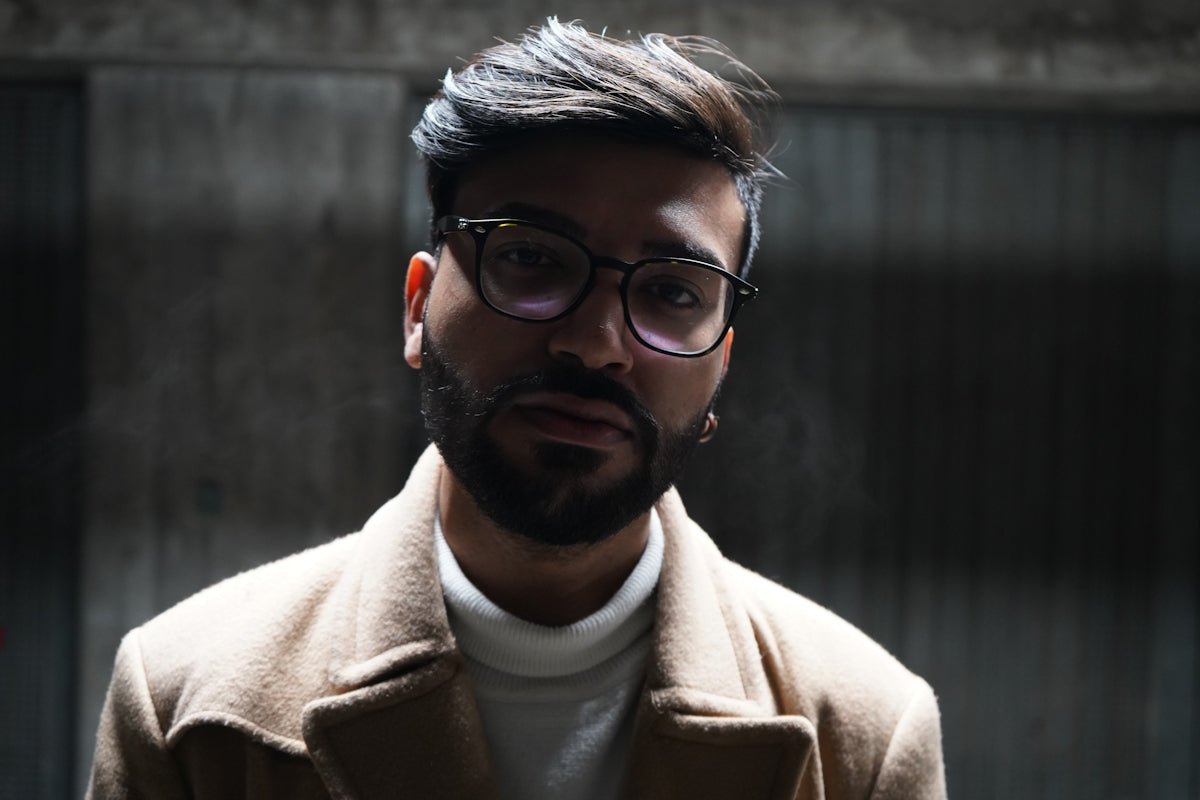 man in brown coat wearing black framed eyeglasses
