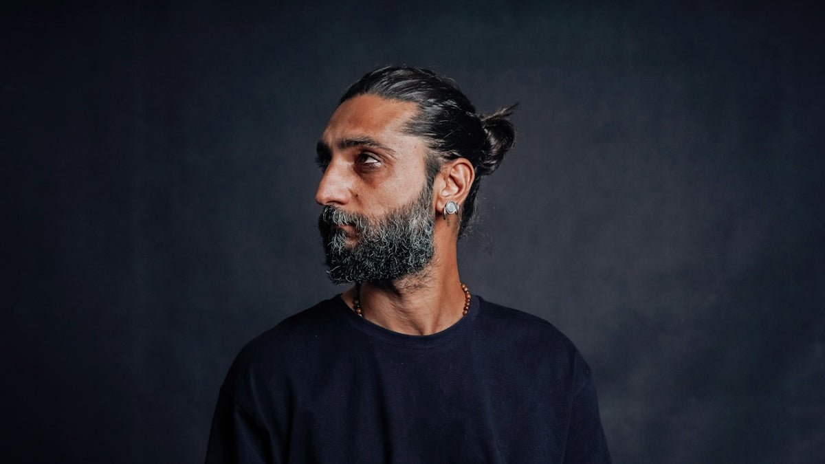 A man with a beard looks to the side.