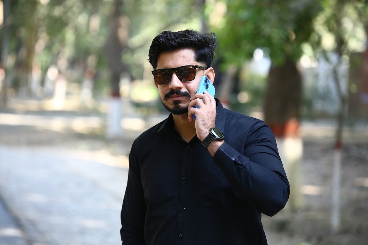 Man in sunglasses talking on a cell phone outdoors
