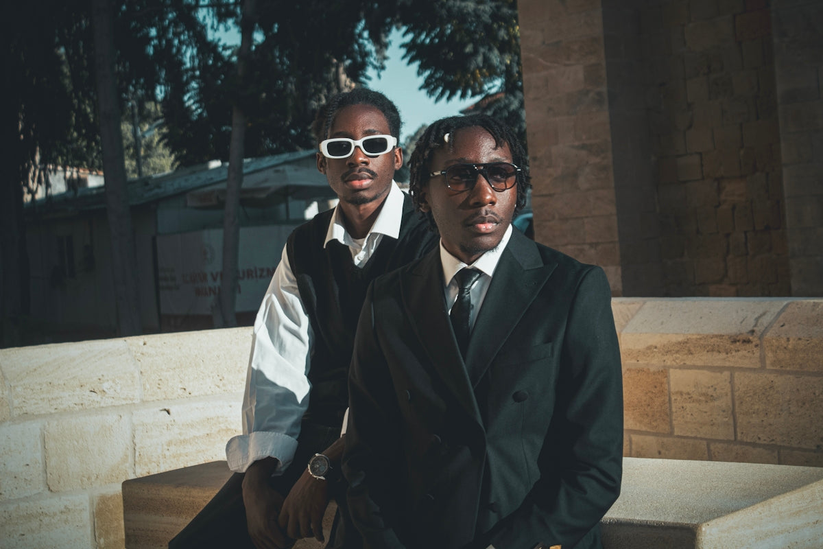 Two stylish young men in sunglasses outdoors.