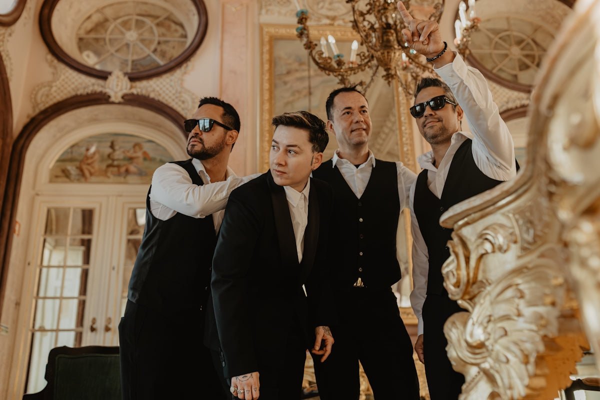 Four men in formal wear posing in opulent interior