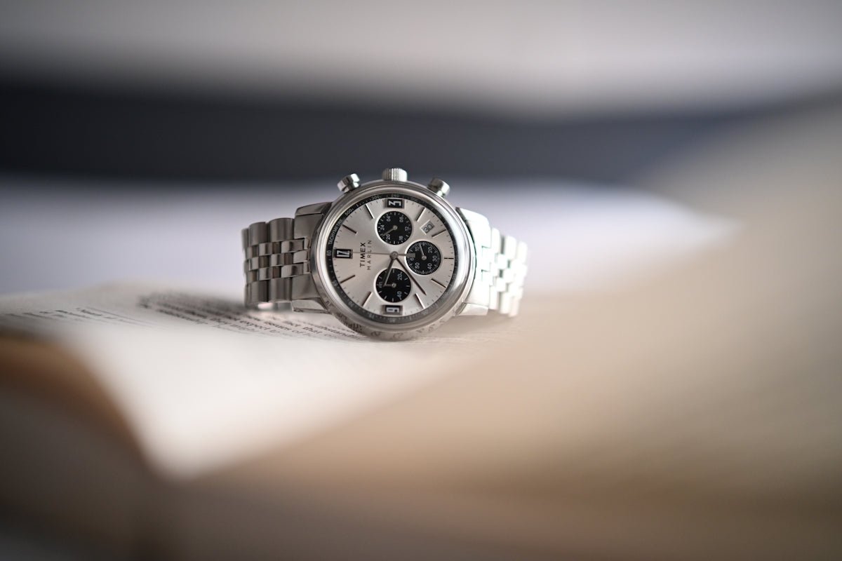 A silver chronograph watch with a metal band.