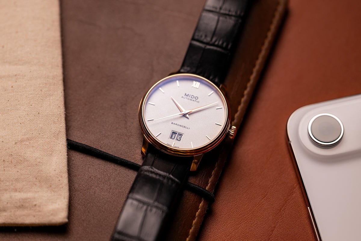 A classic wristwatch with a white face and black strap.