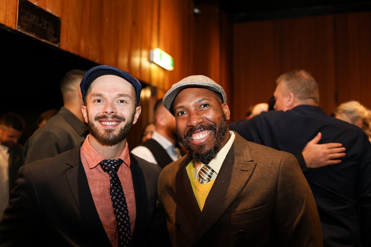 Two smiling men in hats and suits