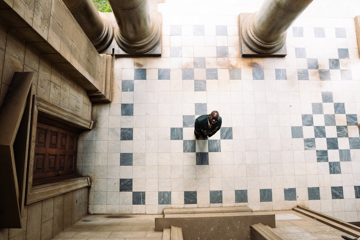 Couple embracing on a patterned tiled floor.