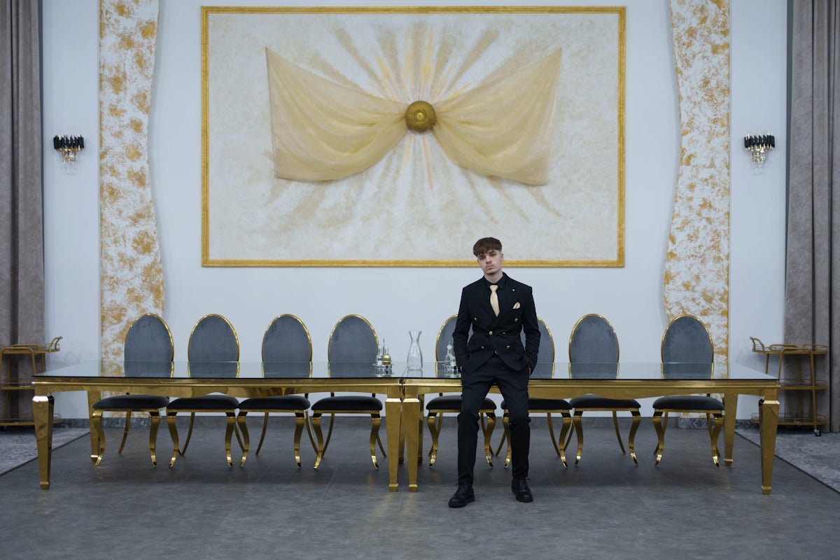 Man in suit standing in grand hall with long table